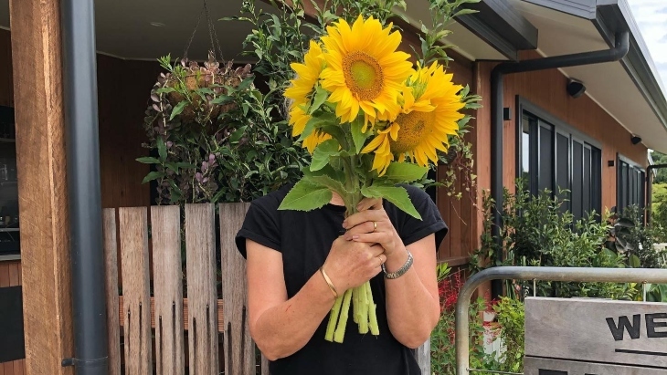 Holding a bunch of sunflowers