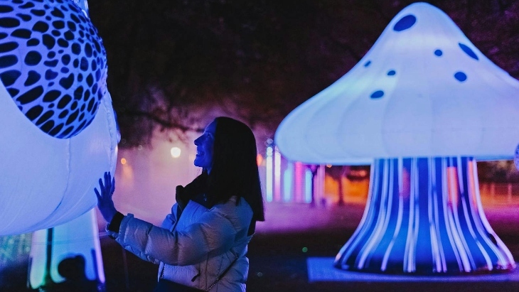 Woman touching glowing installation at Electric Wonderland Melbourne