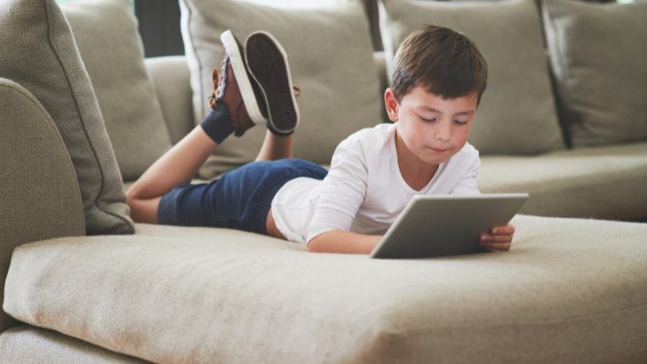 Boy on ipad on couch