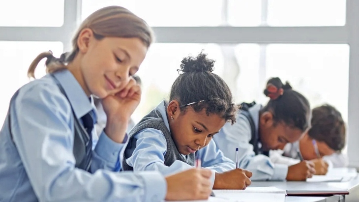 Female students in a classroom wearing school uniforms