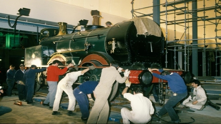 Workers restoring an old locomotive