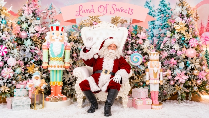 Santa sitting in a chair surrounded by the land of sweets