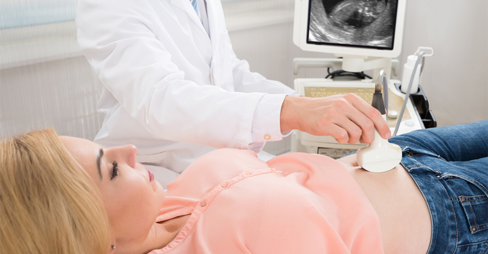 Doctor Moving Ultrasound Transducer On Pregnant Woman's Stomach
