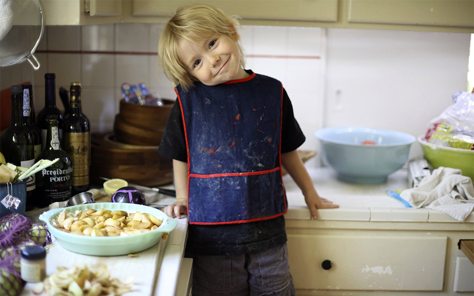 Young boy learning how to cook 960x500