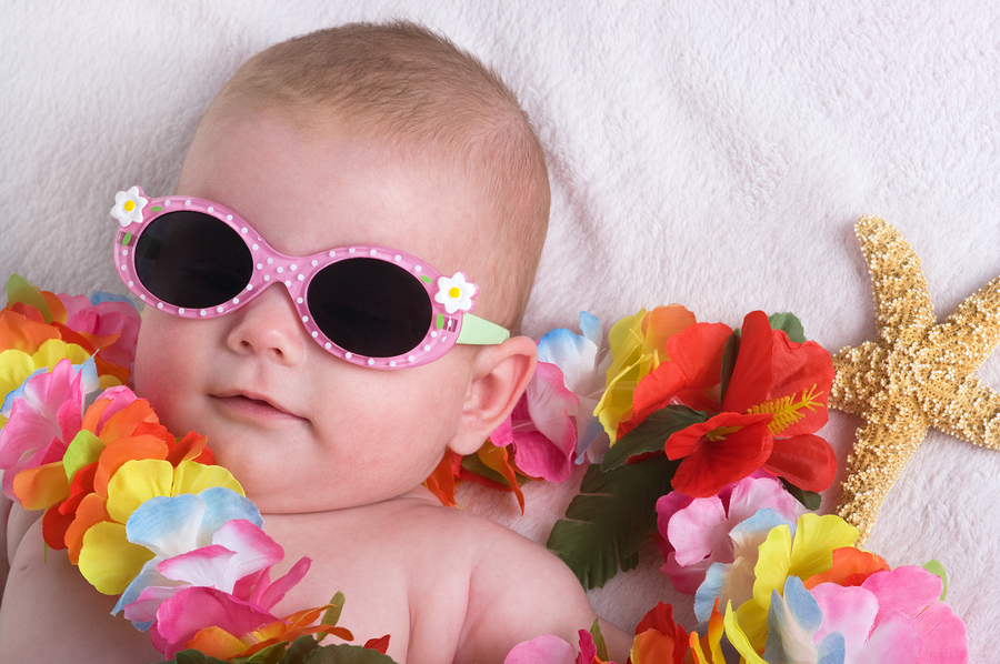 Beautiful baby girl with lei sun glasses and a starfish on vacation