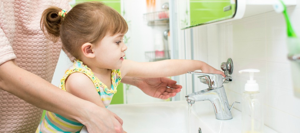 kid girl washing hands with mom help in bathroom