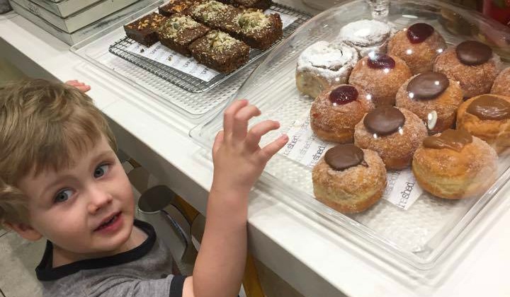 boy reaching for donuts