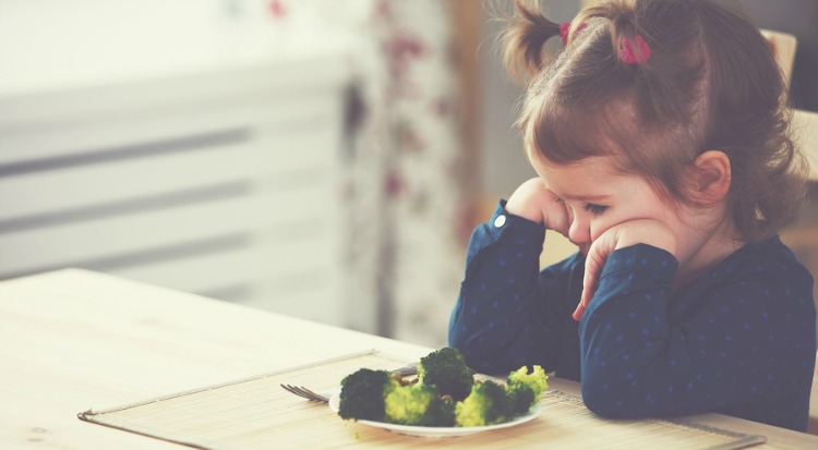 child girl does not like and does not want to eat vegetables